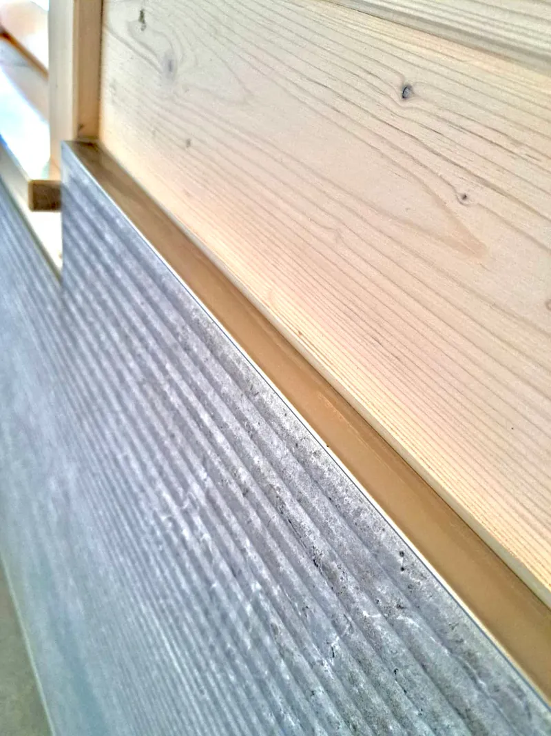 Anschlussdetail von Bodenfliesen in Holzoptik an die Wand