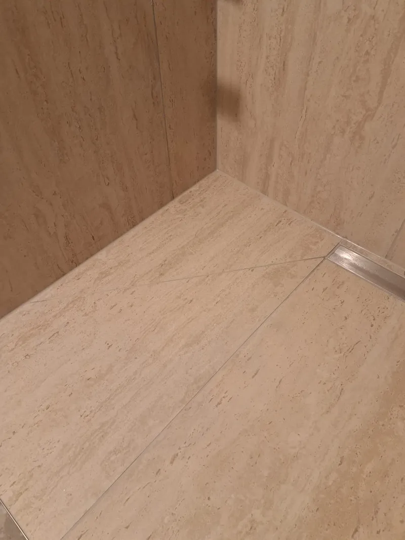 Wandnische in der Dusche in Travertinoptik mit Edelstahlkante