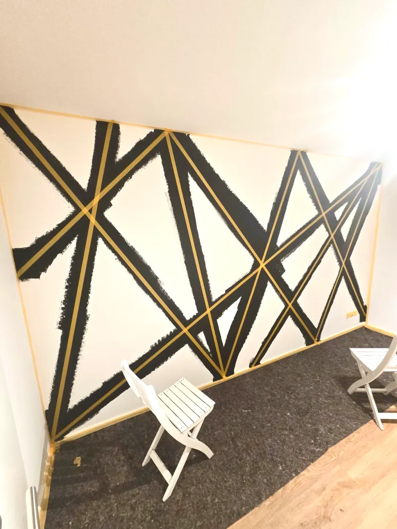 Geometrische Akzentwand in Schwarz und Gold