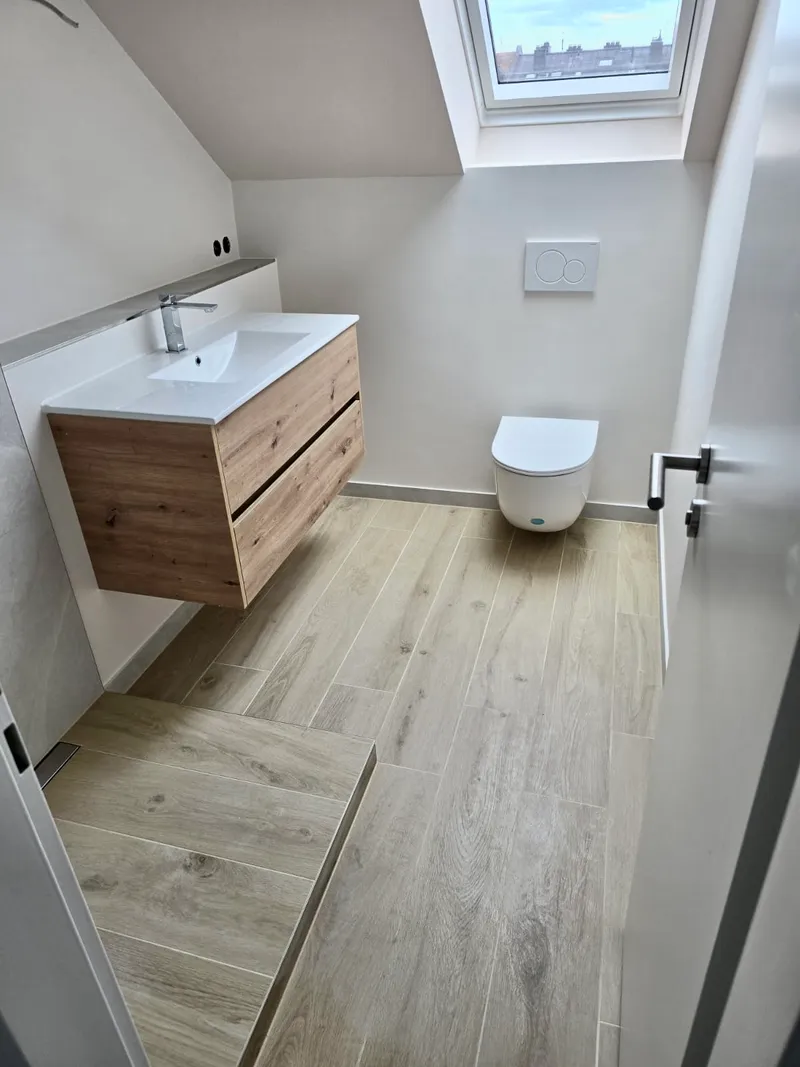 Gäste-WC im Dachgeschoss mit Holzoptik-Fliesen und schwebendem Waschtisch